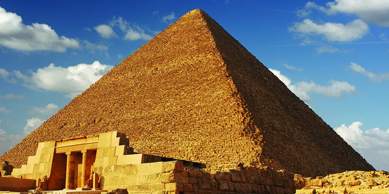 Khufu Pyramid on the Giza Plateau, Egypt, showing its massive limestone structure under a clear sky.