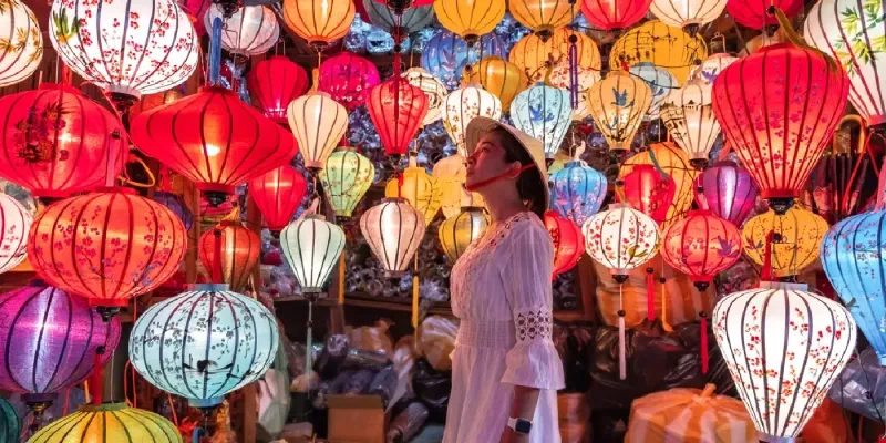 Woman soaking in the glow of Hoi An’s iconic lanterns.