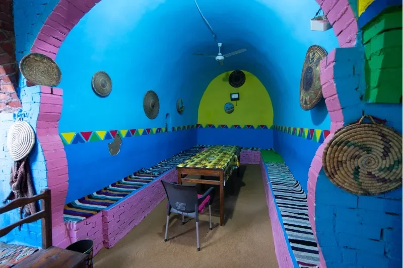 All'interno di una casa nubiana dai colori vivaci, manufatti tessili sono esposti ai turisti in visita durante una sera di primavera.
