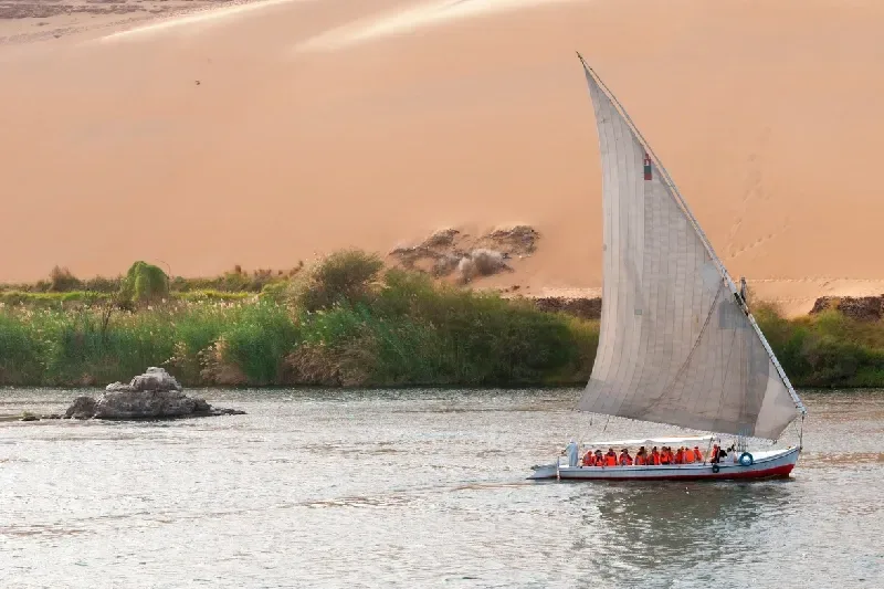 Eine Gruppe von Touristen trägt Schwimmwesten, als sie eine Felucca-Tour auf dem Nil in Assuan