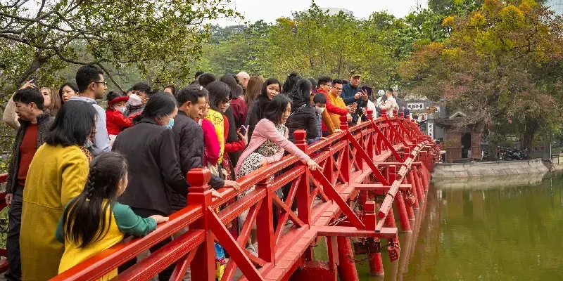 El pueblo vietnamita se agolpa en el puente The Huc para dirigirse al templo Ngoc Son, situado en el lago Hoan Kiem de Hanói.
