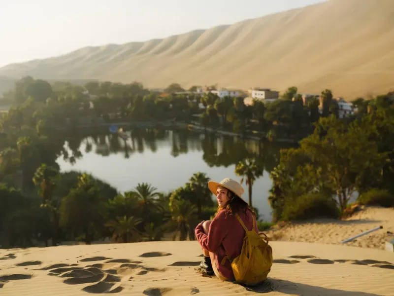 Woman exploring Huacachina oasis during trip to Peru