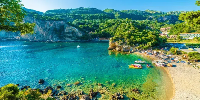 Hermosa playa y barco en Paleokastritsa, isla de Corfú, Grecia.
