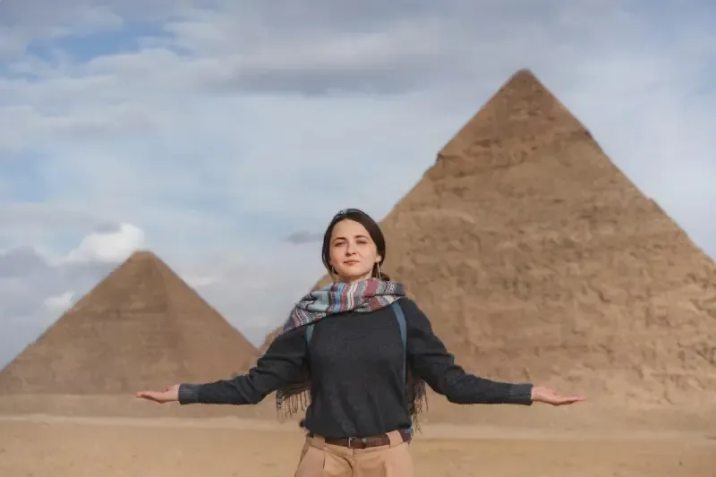 Una donna cammina vicino alle piramidi di Giza.