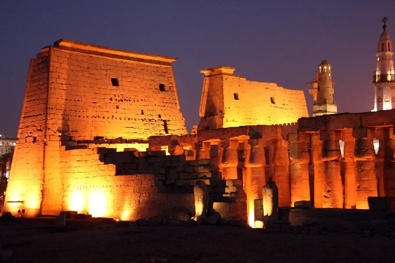Blick auf den Amun-Tempel und seine Moschee in Luxor bei Nacht.