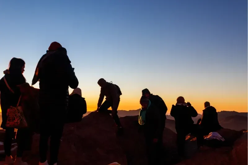 Persone che ammirano l'alba sulla cima del Monte Sinai