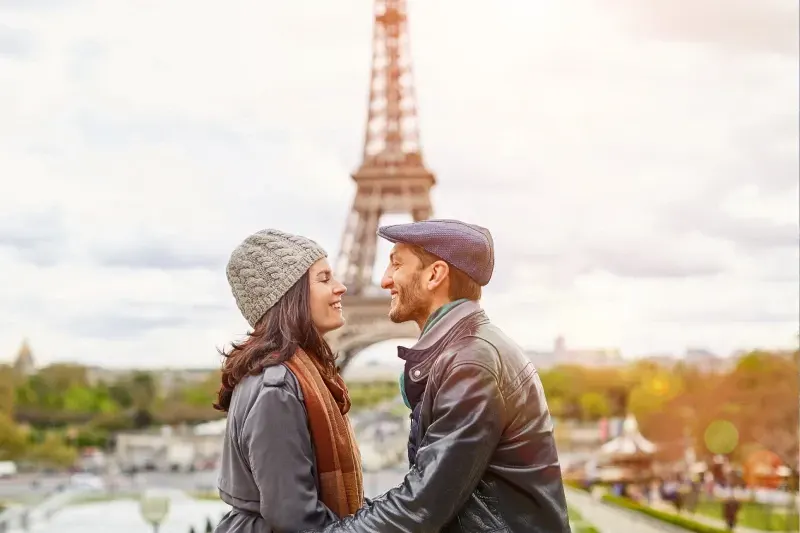 Junges verliebtes Paar in Paris, das gemeinsam einen romantischen Moment in der Stadt genießt.