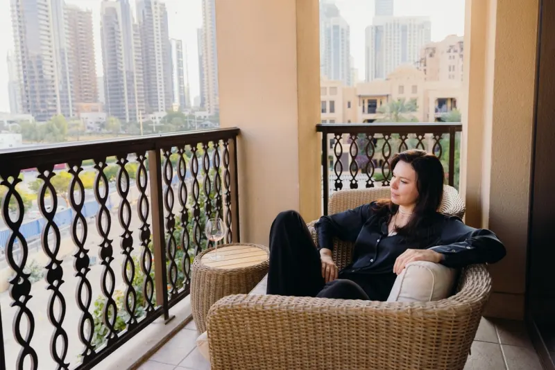 Beautiful Woman Relaxing at Patio Enjoying View of Dubai hotels
