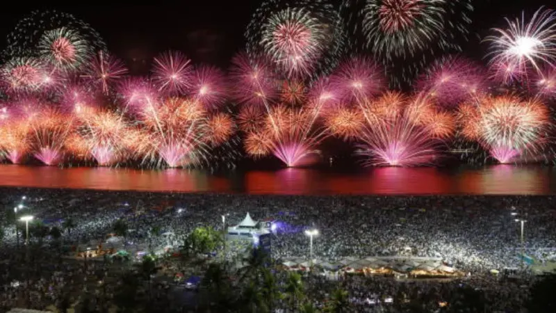 Spektakuläres Feuerwerk über Rio de Janeiro, Brazil, am Silvesterabend, mit bunten Lichtern über dem Meer, der Küste und der lebendigen Skyline der Stadt.
