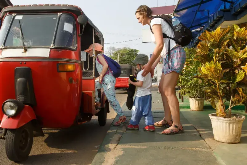 Madre e hijos subiendo a un tuk-tuk.