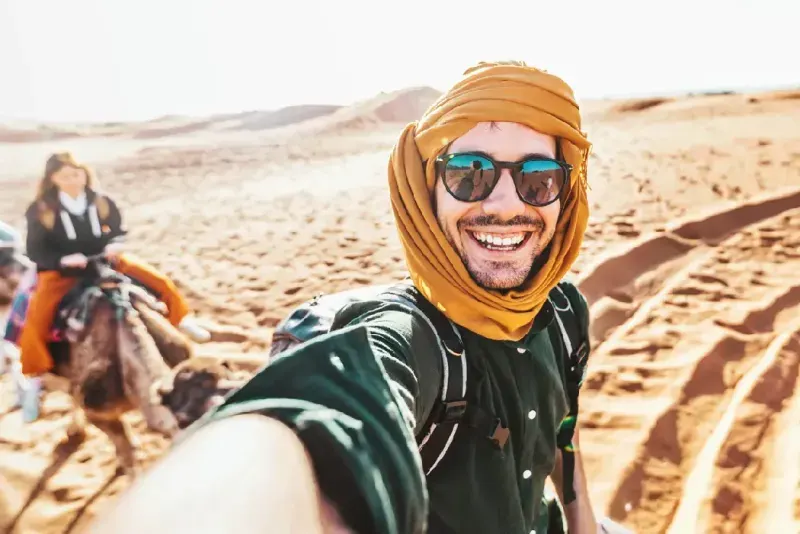 turista-feliz-disfrutando-de-un-paseo-en-camello-en-grupo-por-el-desierto