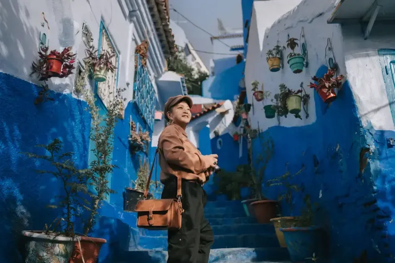Asian Chinese female tourist standing at alley in Chefchaouen, Morocco