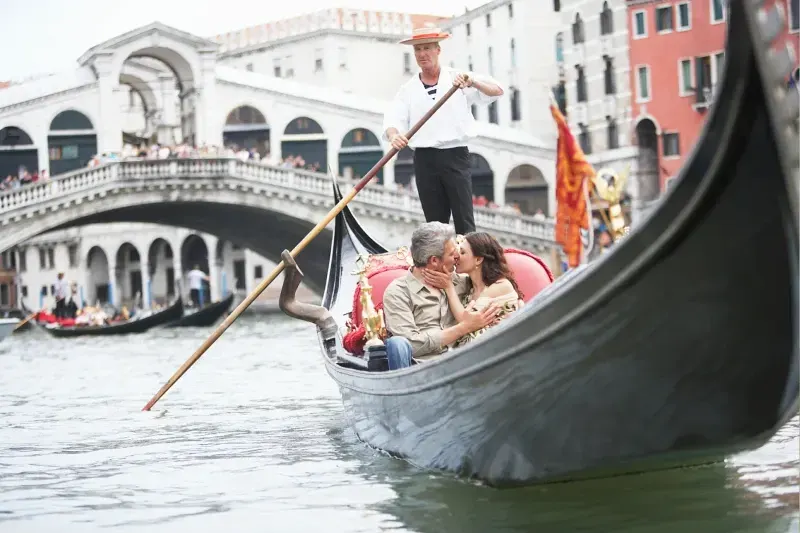 Paar küsst sich romantisch in einer Gondel auf den Kanälen von Venedig in Italien.