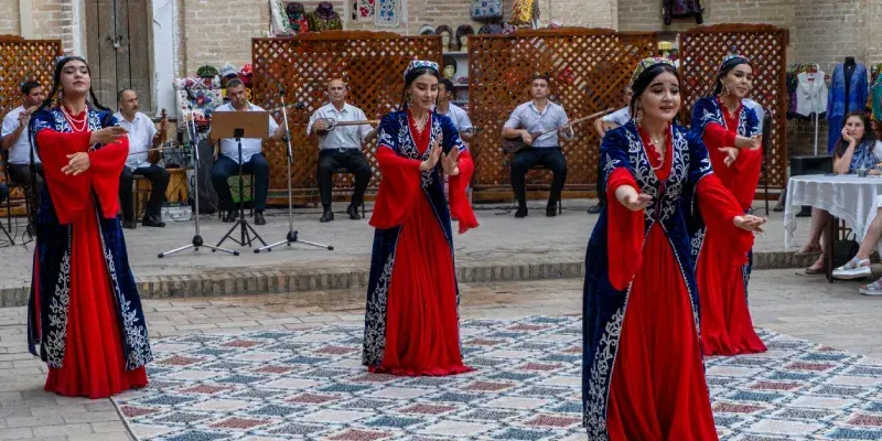 Persone che assistono a uno spettacolo di danze uzbeke nella Città Vecchia di Bukhara, Uzbekistan