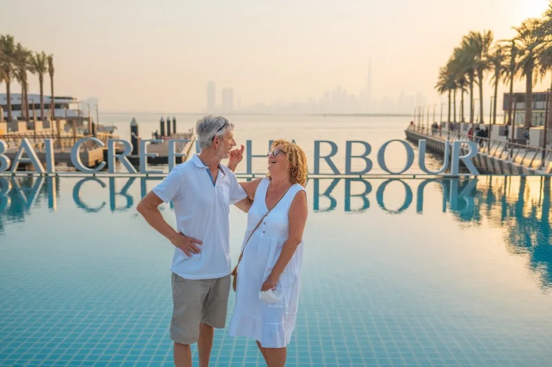 Couple enjoying Dubai Creek Harbour sunset view.