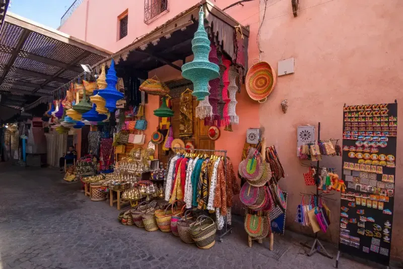 Un vibrante puesto de mercado callejero en la Medina de Marrakech, que exhibe coloridas artesanías, textiles y recuerdos hechos a mano.