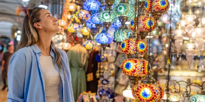 Smiling woman looking at Turkish lamps in the Grand Bazaar.