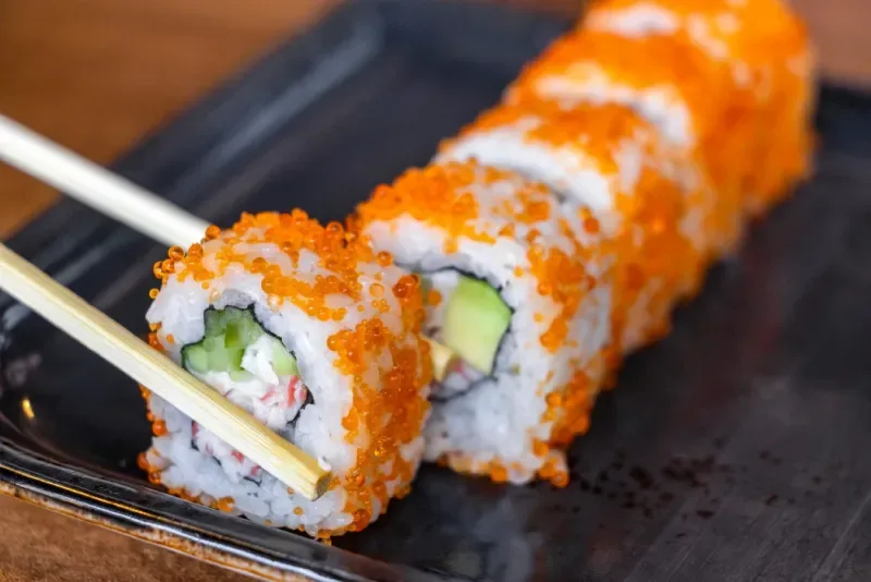 Rollos de sushi con salmón, queso y caviar.