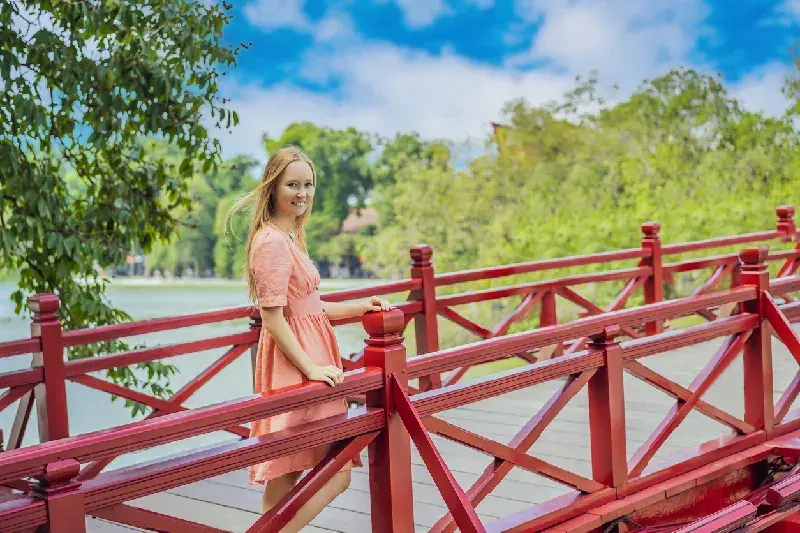 Traveler at Hoan Kiem Lake and Hanoi's iconic Red Bridge.