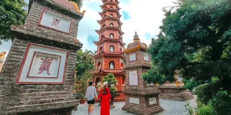 Couple standing in front of Tran Quoc Pagoda in Hanoi