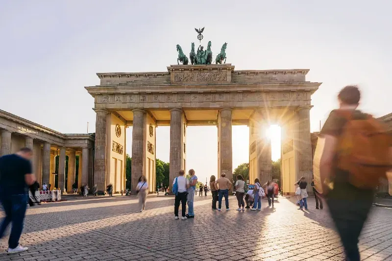 Sonnenuntergang am Brandenburger Tor in Berlin, Touristen zu Fuß