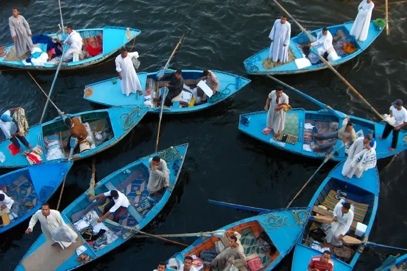 diversi venditori ambulanti egiziani in galabeya espongono attivamente le loro merci colorate