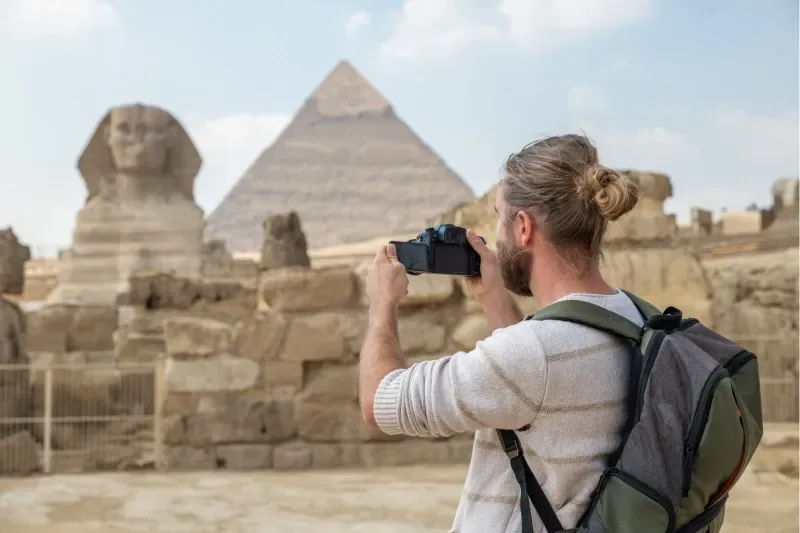Turista scatta una foto alla Sfinge e alla Piramide in Egitto
