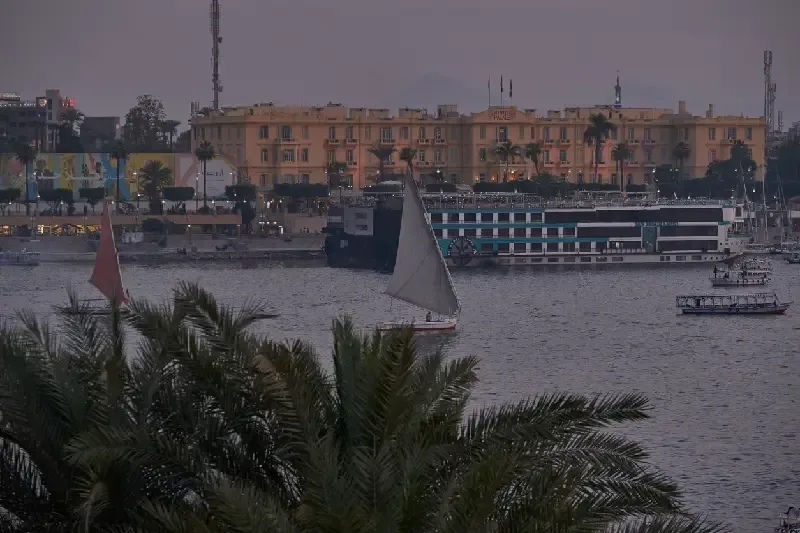 Nachtaufnahme in Luxor, Ägypten vom Westufer mit Blick über den Nil auf das Winter Palace Hotel am Ostufer