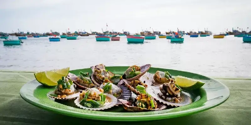 Aperitivo de mariscos: vieiras y verduras.