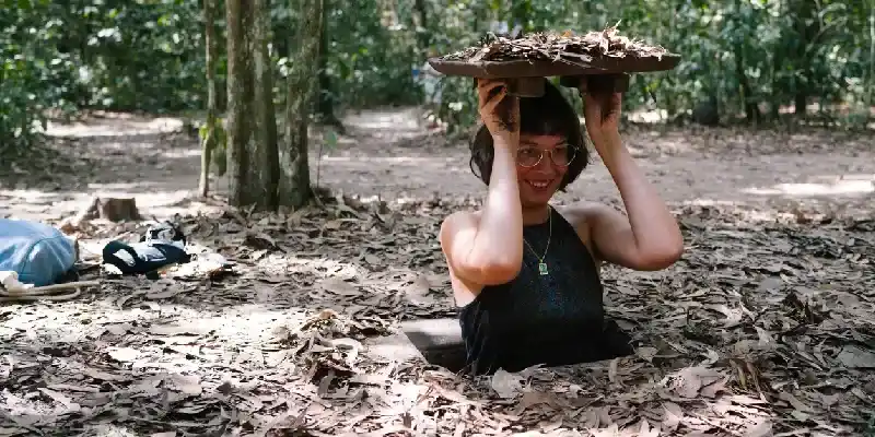 Un turista emerge por una salida camuflada de un túnel de Củ Chi.