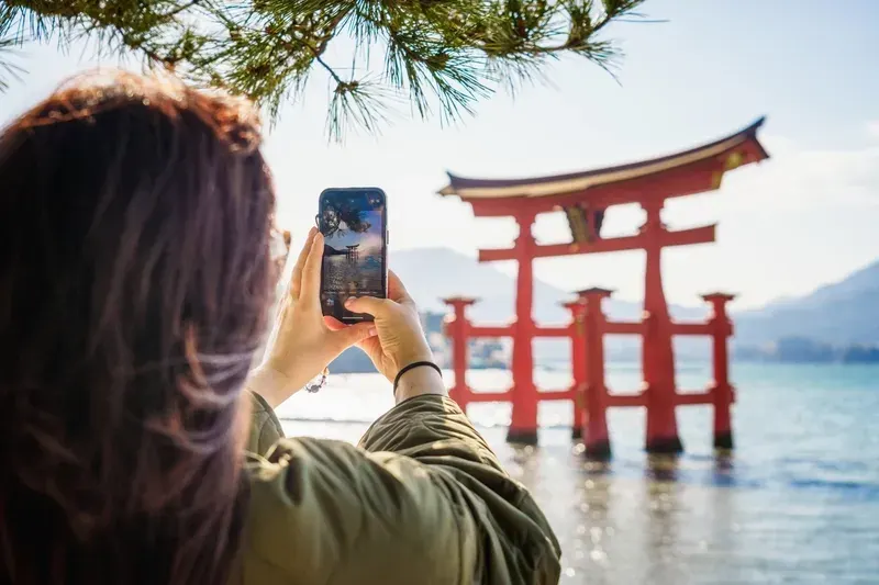 turista-fotografando-o-portao-torii-flutuante-de-itsukushima-em-miyajima