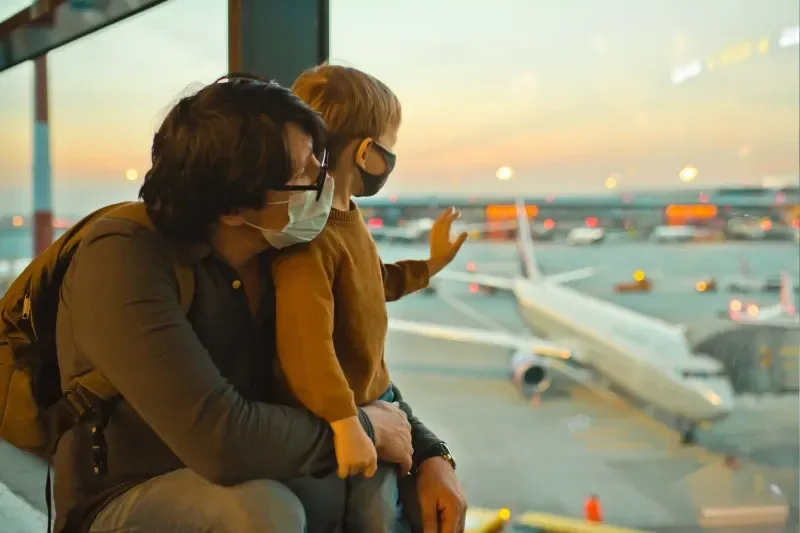 Familie mit Schutzmasken am Flughafen während der COVID-19-Pandemie