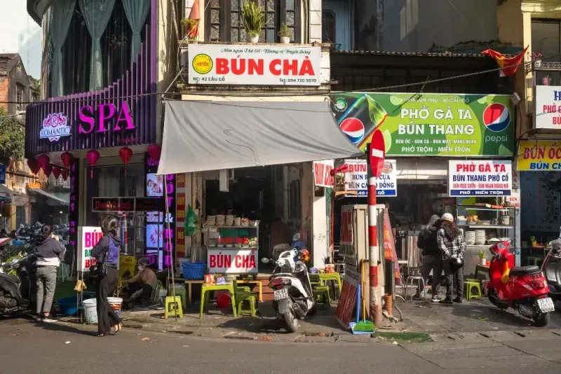 La gente curiosea entre los pequeños restaurantes y tiendas del Barrio Antiguo de Hanói, Vietnam.