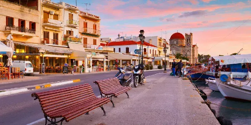 vista-del-paseo-maritimo-con-la-iglesia-ekklisia-isodia-theotokou-y-barcos-pesqueros-en-egina-grecia