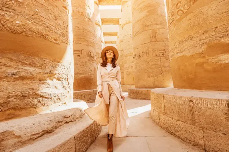 Una viaggiatrice felice esplora le rovine dell'antico tempio di Karnak, luxor, egitto