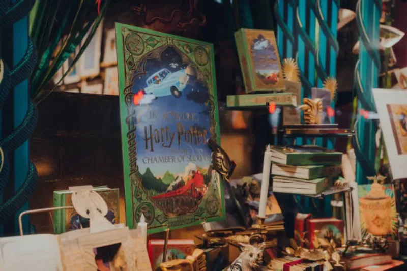 Harry-Potter-Bücher dekorativ im Schaufenster des MinaLima Studios in Covent Garden, London, UK, präsentiert.