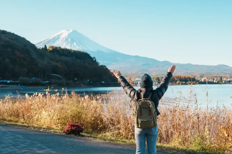 turista-de-bracos-abertos-admirando-o-monte-fuji-as-margens-do-lago-kawaguchiko