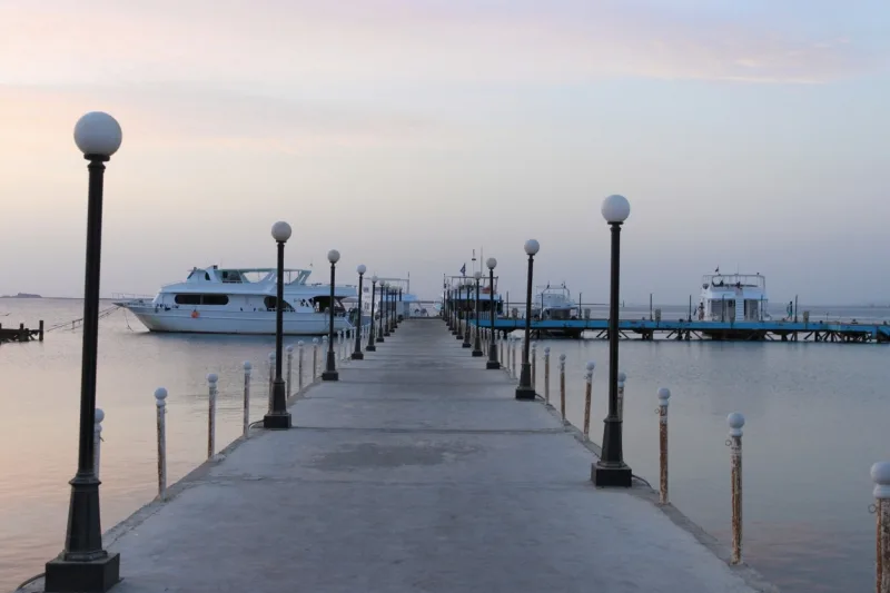 Pier and ships on the sea. The pre-dawn sky. A minute before sunrise. Red sea, Egypt ports