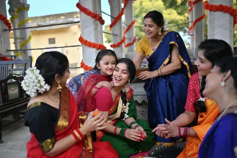 A girl hugs her mother making traditional motichur laddoos in Rajasthan.