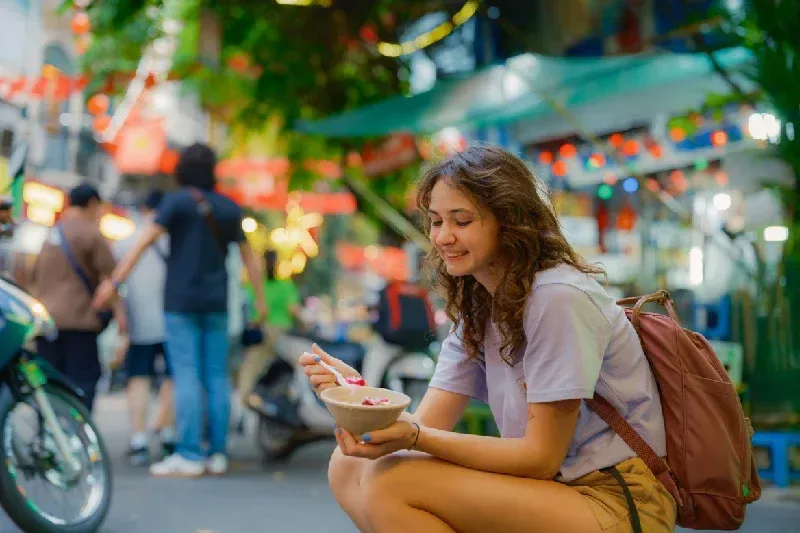 Woman eating Vietnamese fruit salad (hoa qua dam) 