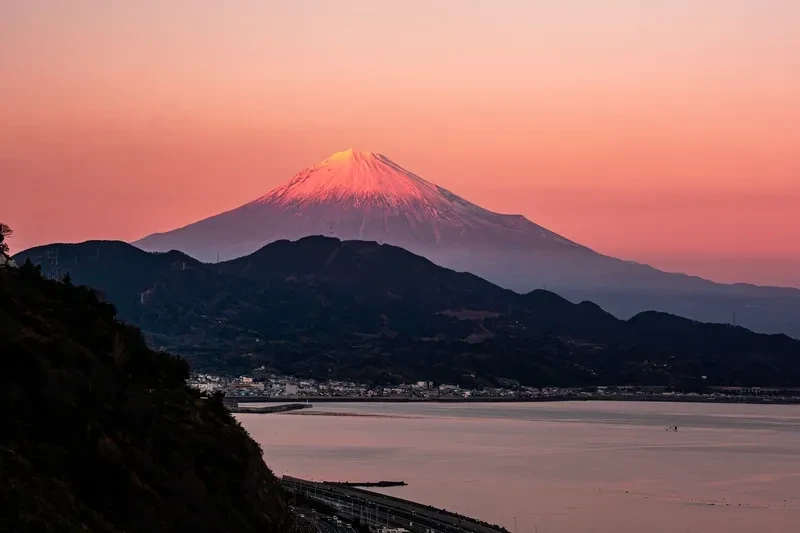 monte-fuji-avermelhado-ao-amanhecer-com-baia-e-litoral-ao-fundo