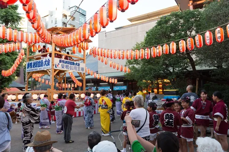 festival-japones-de-verao-com-pessoas-dançando-e-lanternas-vermelhas-nas-ruas