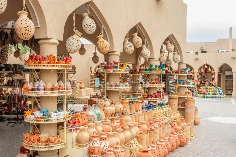 Souvenir artigianali e giare in ceramica nel mercato di Nizwa, Oman.