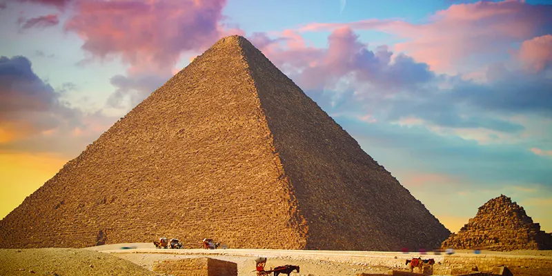 The Great Pyramid of Giza in Egypt, towering majestically over the desert, with the largest pyramid of Khufu at the forefront, showcasing one of the most iconic landmarks of the ancient world.