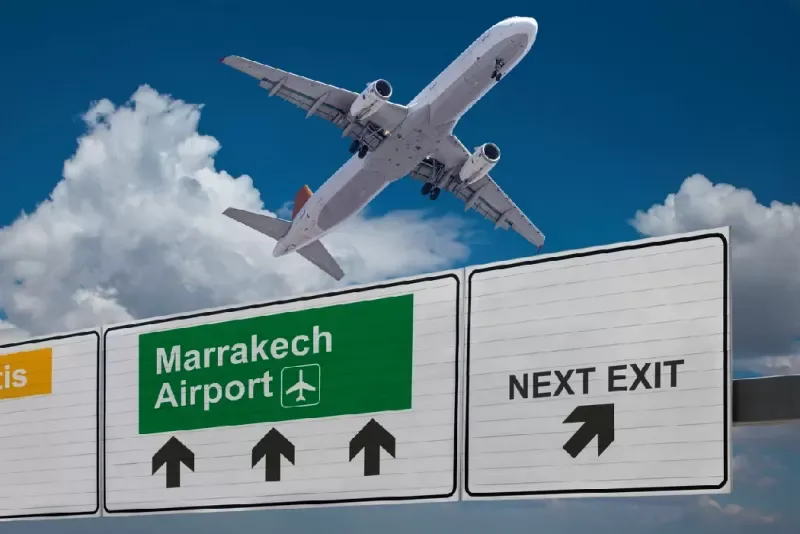 Señal hacia el aeropuerto de Marrakech con avión despegando