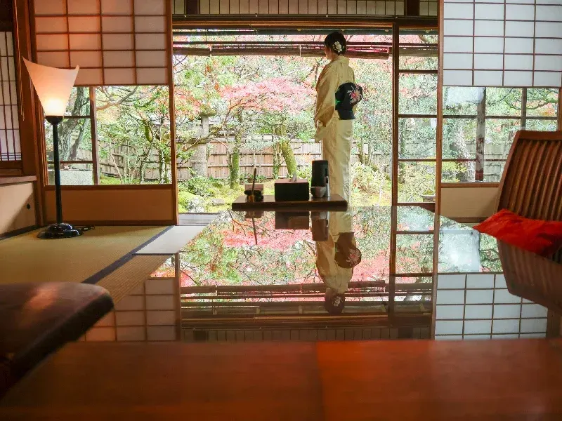 Una mujer japonesa relajándose en la habitación de un hostal tradicional japonés.