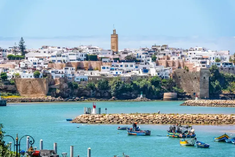 Vista panorámica del río Bou Regreg con coloridos barcos de pesca flotando suavemente sobre el agua