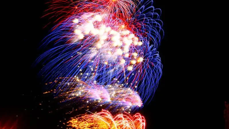 Spektakuläres Feuerwerk über dem Hafen von Cape Town, South Africa, mit bunten Lichtern, die sich im Wasser spiegeln, und der nächtlichen Skyline im Hintergrund.