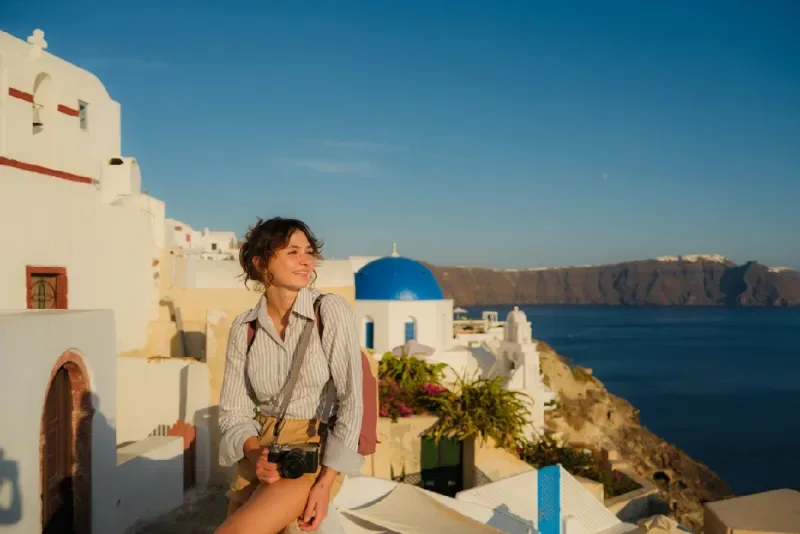 Mujer contemplando la vista panorámica del pueblo de Oia en la isla de Santorini.