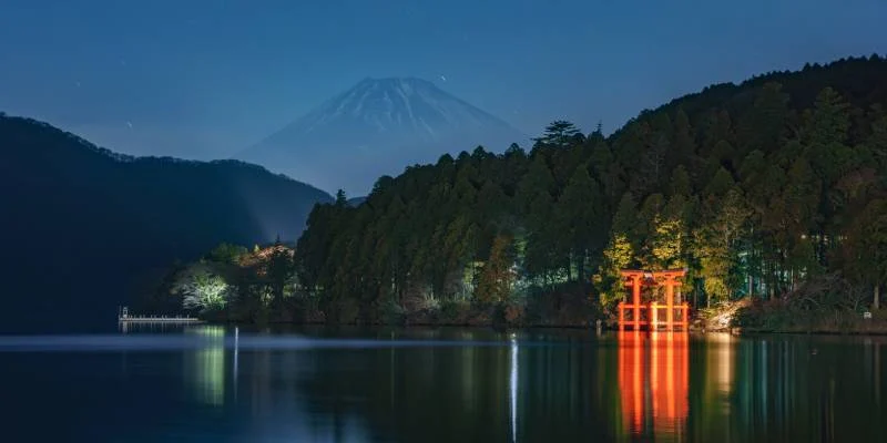 Vista notturna di Moto Hakone con il torii e il Monte Fuji